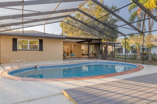 view of swimming pool with a patio area and glass enclosure