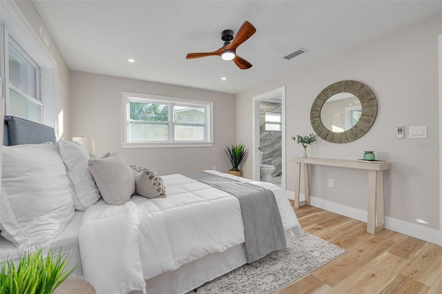 bedroom with ceiling fan, ensuite bathroom, a textured ceiling, and light hardwood / wood-style floors