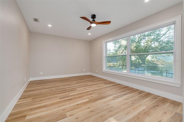 spare room featuring a wealth of natural light, light hardwood / wood-style floors, and ceiling fan