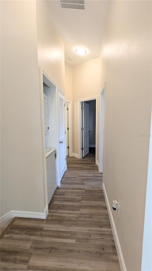 9060 Moonlit Meadows Loop, Riverview, FL 33578 - hallway with stacked washer / drying machine, wood finished floors, and baseboards