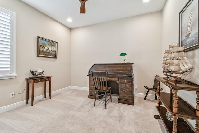 carpeted home office featuring ceiling fan