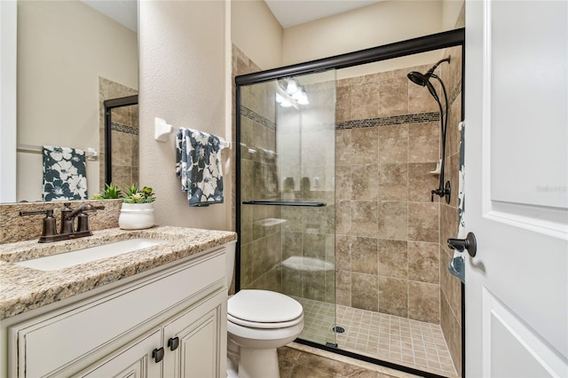 bathroom featuring tile patterned flooring, vanity, toilet, and walk in shower