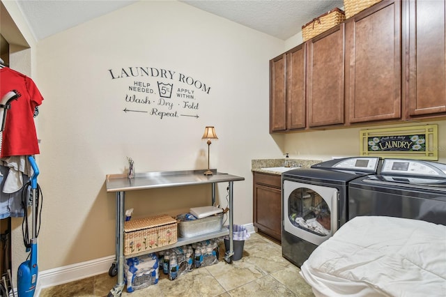 clothes washing area with cabinets, a textured ceiling, and separate washer and dryer