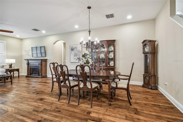 dining room with dark wood-type flooring and a chandelier