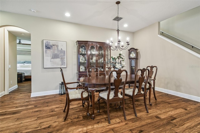 dining area with dark hardwood / wood-style floors and a chandelier