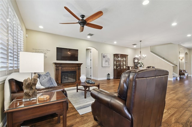 living room featuring dark hardwood / wood-style flooring and ceiling fan with notable chandelier