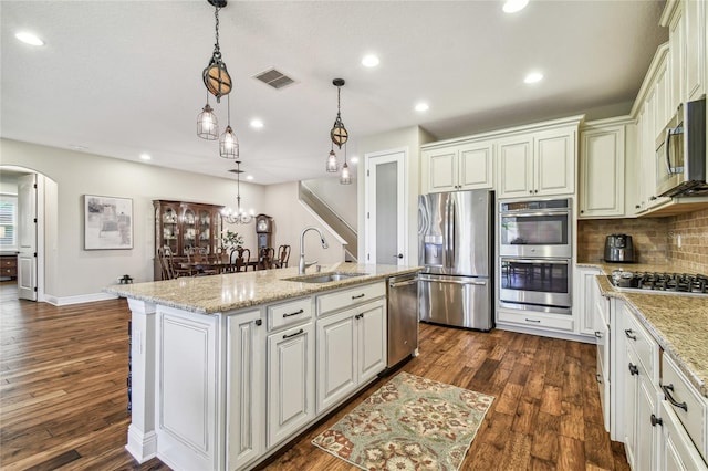 kitchen with pendant lighting, a center island with sink, sink, dark hardwood / wood-style floors, and stainless steel appliances