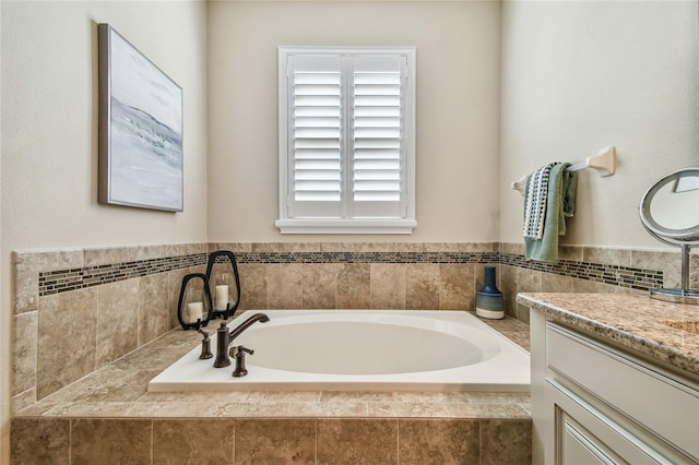 bathroom featuring vanity and a relaxing tiled tub