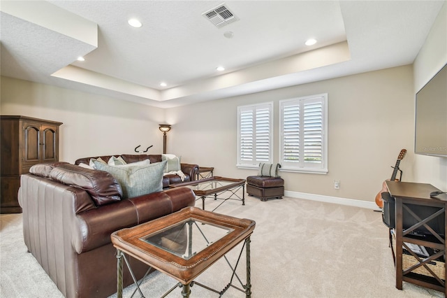 carpeted living room with a tray ceiling