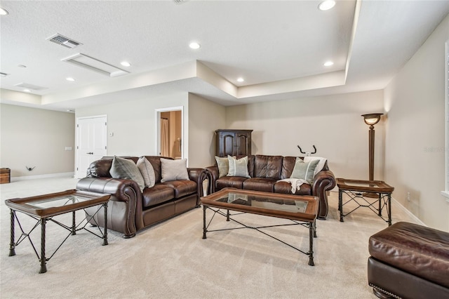 carpeted living room featuring a tray ceiling and a textured ceiling