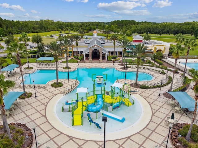 8144 Sequester Loop, Land O Lakes, FL 34637 - community pool with a water play area, a water slide, and view of wooded area