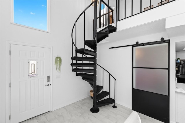 entryway featuring a towering ceiling and a barn door