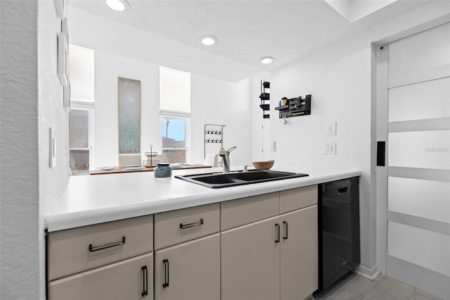 kitchen featuring a textured ceiling, sink, and black dishwasher