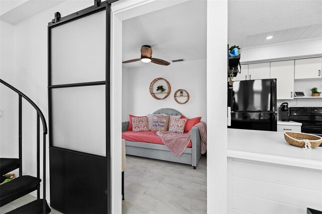 interior space featuring a barn door and ceiling fan