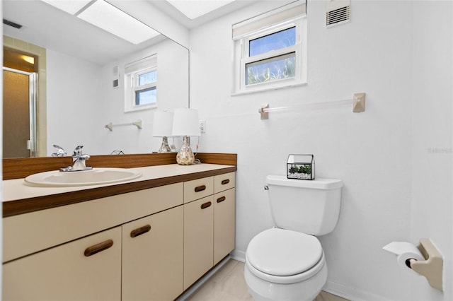 bathroom featuring vanity, toilet, and a shower with door