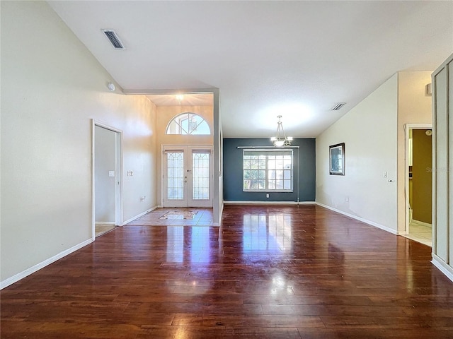 interior space with dark hardwood / wood-style flooring, french doors, vaulted ceiling, and a notable chandelier