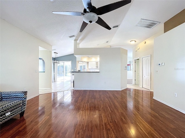 unfurnished living room with a textured ceiling, ceiling fan, hardwood / wood-style floors, and lofted ceiling