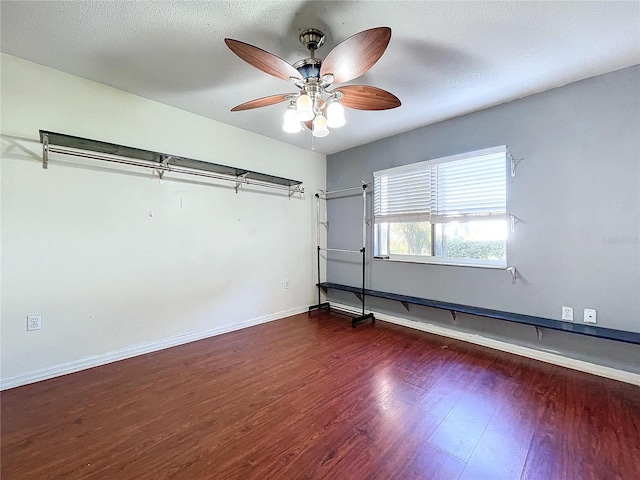 spare room with a textured ceiling, ceiling fan, and dark wood-type flooring