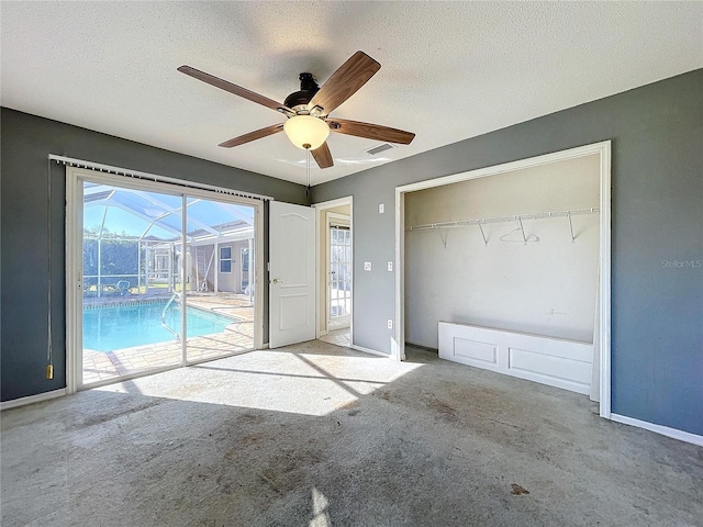 unfurnished bedroom featuring light carpet, access to outside, ceiling fan, a textured ceiling, and a closet