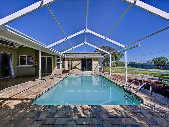 view of pool with glass enclosure and a patio area