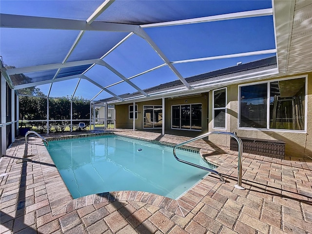 view of swimming pool with glass enclosure and a patio