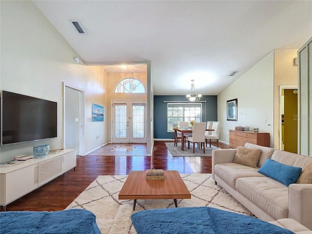 living room with french doors, vaulted ceiling, a notable chandelier, and hardwood / wood-style floors