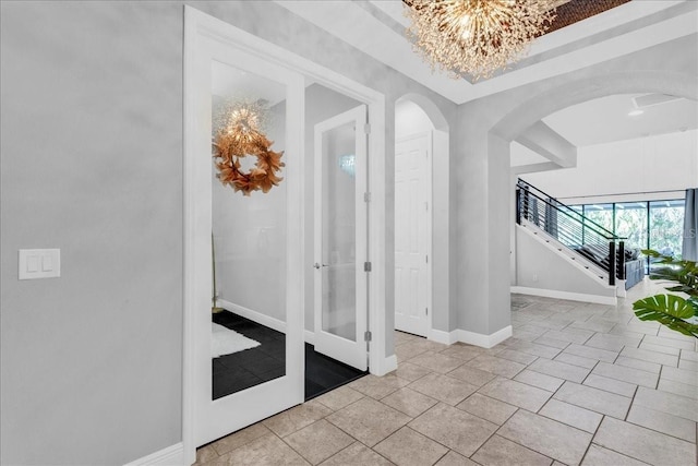 entrance foyer with a raised ceiling and an inviting chandelier