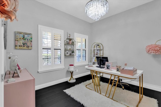 office with dark hardwood / wood-style flooring and an inviting chandelier