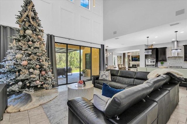 tiled living room with a high ceiling and an inviting chandelier