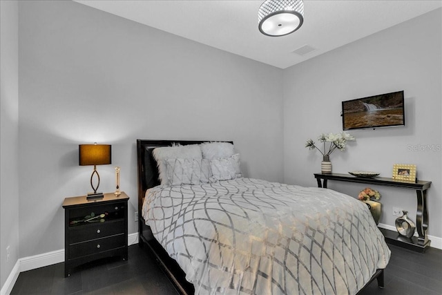 bedroom with dark hardwood / wood-style floors