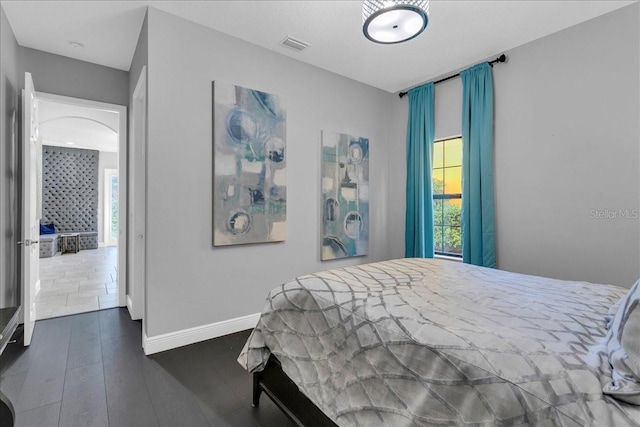 bedroom featuring dark hardwood / wood-style floors and multiple windows