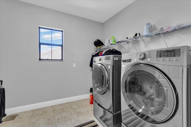 laundry room featuring washer and clothes dryer and light tile patterned floors