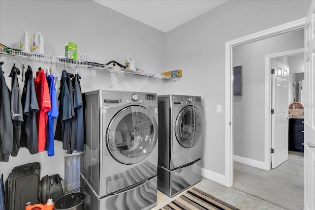 clothes washing area featuring light tile patterned flooring and independent washer and dryer