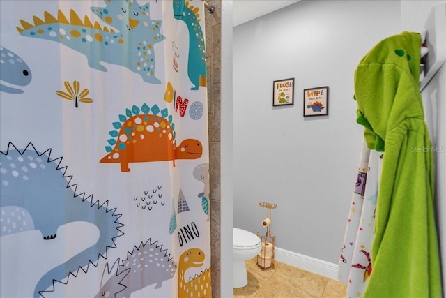 bathroom featuring tile patterned floors, curtained shower, and toilet