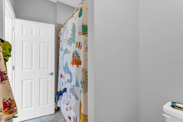 bathroom with tile patterned floors, toilet, and walk in shower