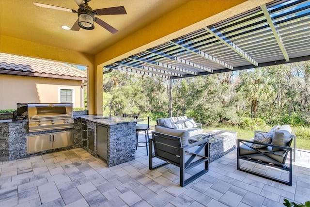 view of patio / terrace with ceiling fan, exterior kitchen, an outdoor living space, area for grilling, and a wet bar