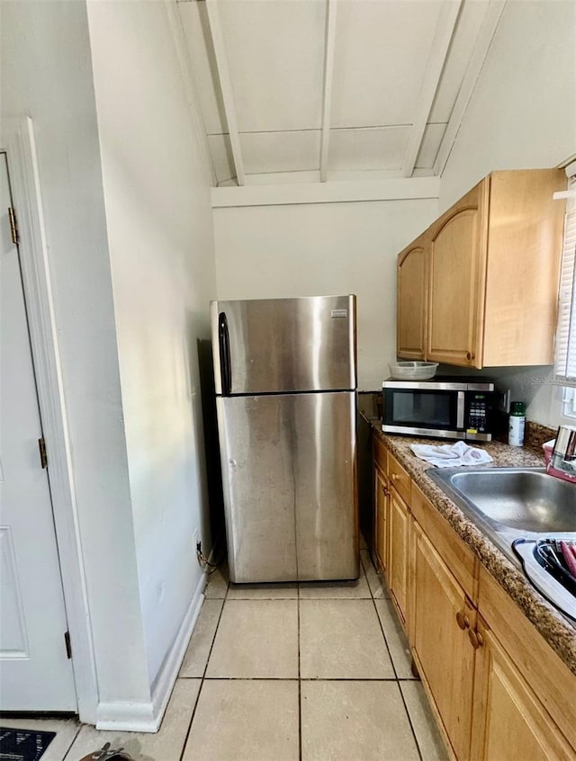 kitchen featuring light brown cabinetry, sink, stainless steel appliances, and light tile patterned flooring