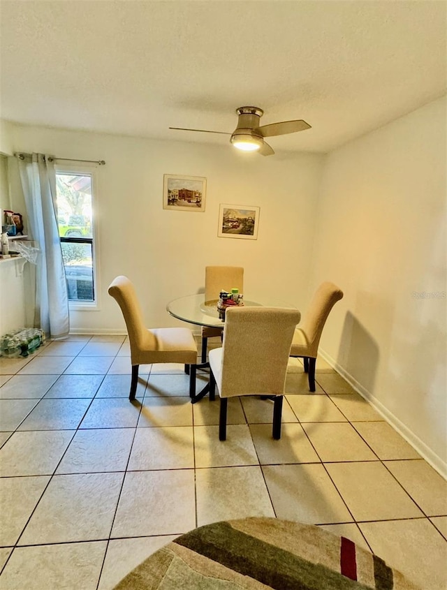 tiled dining space with ceiling fan