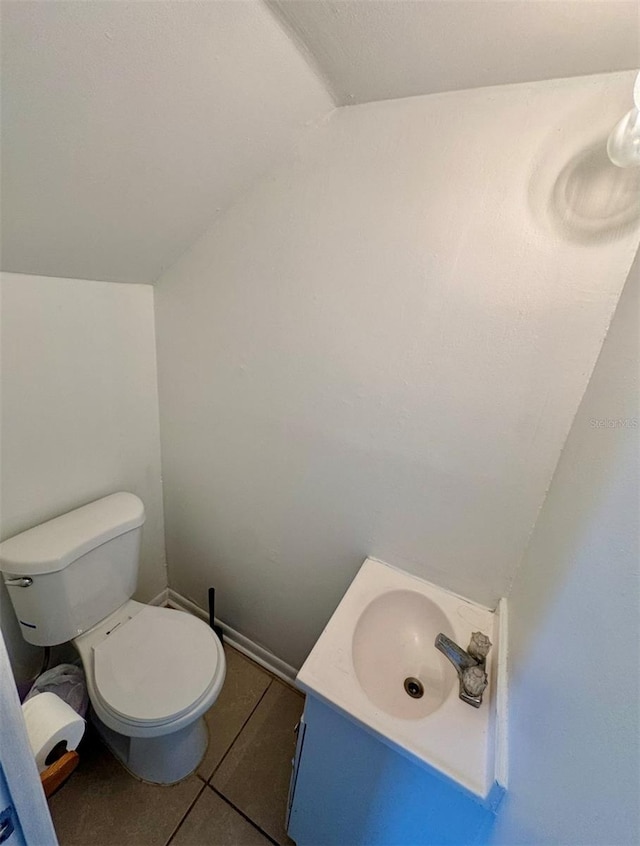 bathroom featuring tile patterned floors, vanity, vaulted ceiling, and toilet