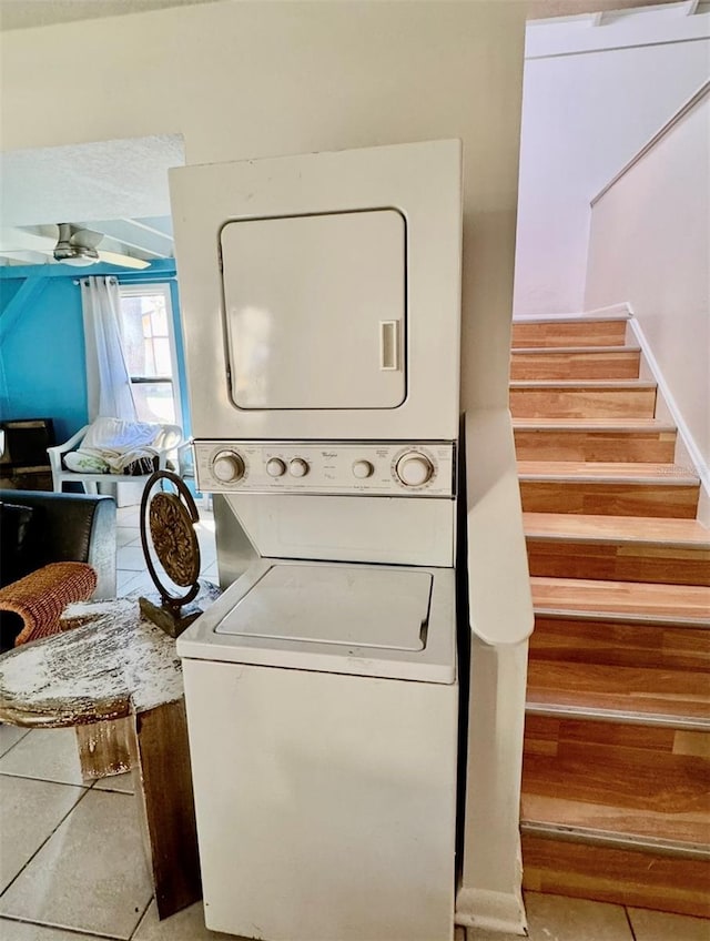 washroom featuring ceiling fan, light tile patterned floors, and stacked washer / drying machine