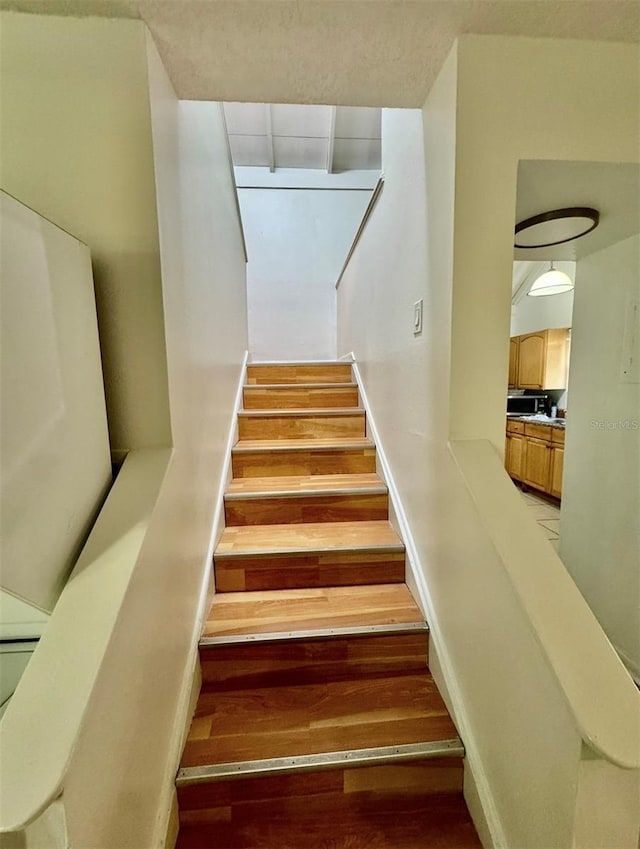 stairway featuring wood-type flooring