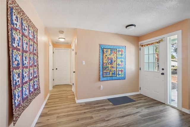 entryway featuring a textured ceiling and light hardwood / wood-style floors