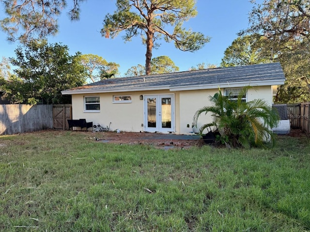 rear view of house with a yard and french doors