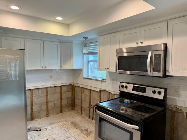 kitchen featuring appliances with stainless steel finishes, tasteful backsplash, and white cabinetry