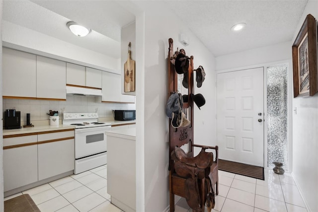 kitchen featuring a textured ceiling, white cabinets, white range with electric stovetop, tasteful backsplash, and light tile patterned flooring