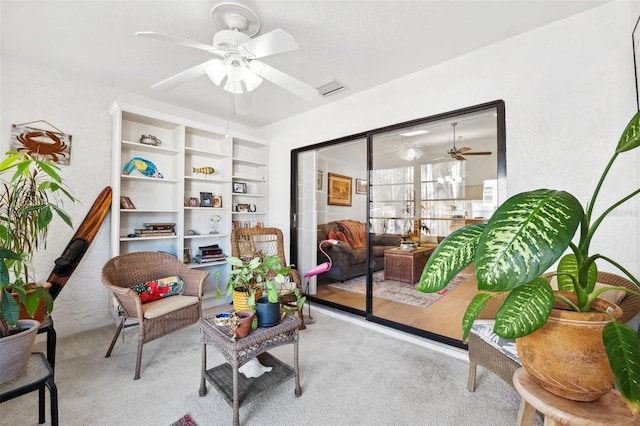 living area featuring ceiling fan and light colored carpet