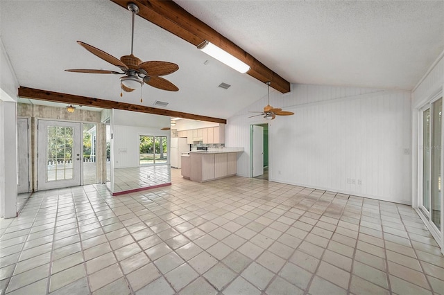 unfurnished living room featuring french doors, vaulted ceiling with beams, ceiling fan, and light tile patterned flooring