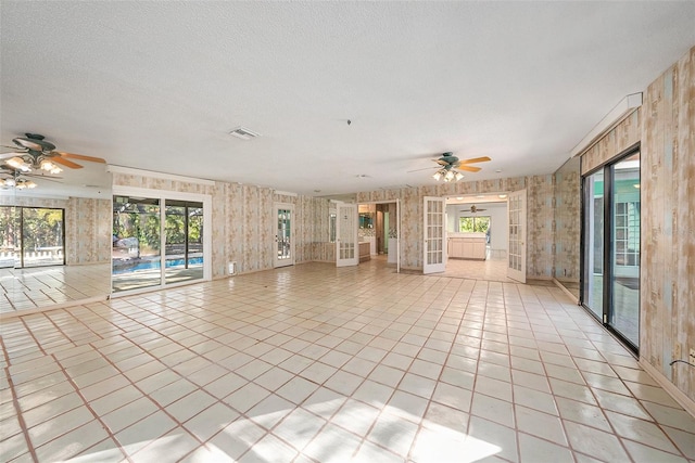 unfurnished living room featuring ceiling fan and light tile patterned flooring