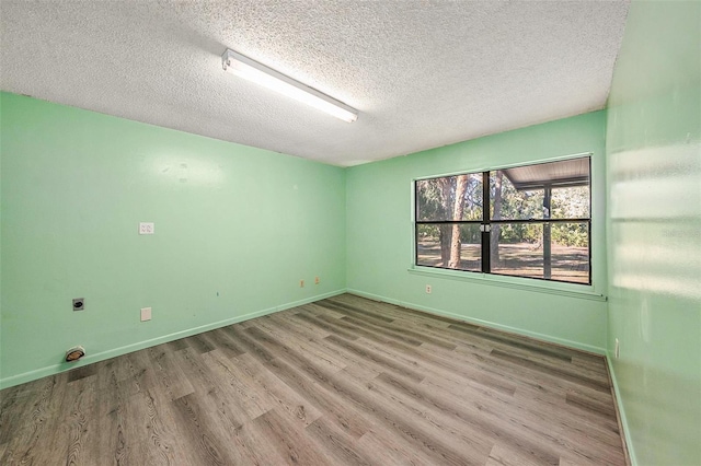 unfurnished room featuring hardwood / wood-style flooring and a textured ceiling