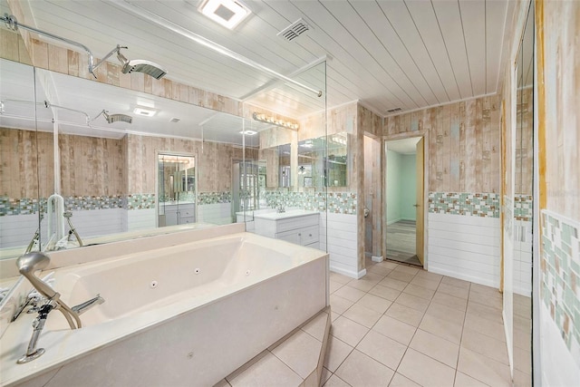 bathroom featuring tile patterned flooring, vanity, and a tub to relax in